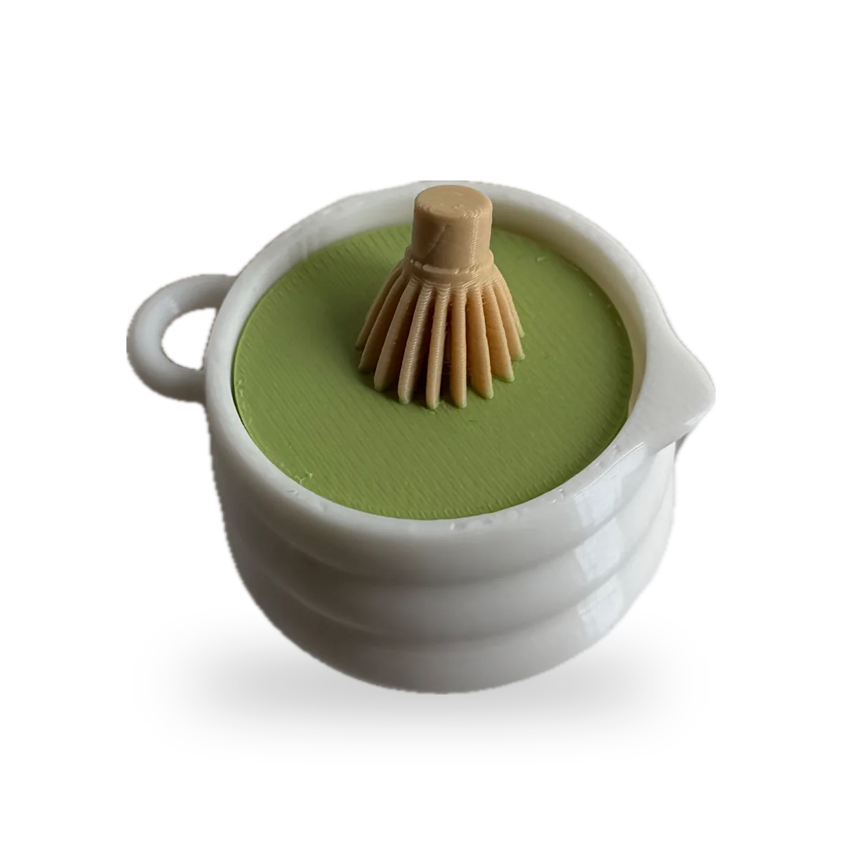 White matcha cup clicker with a bamboo whisk