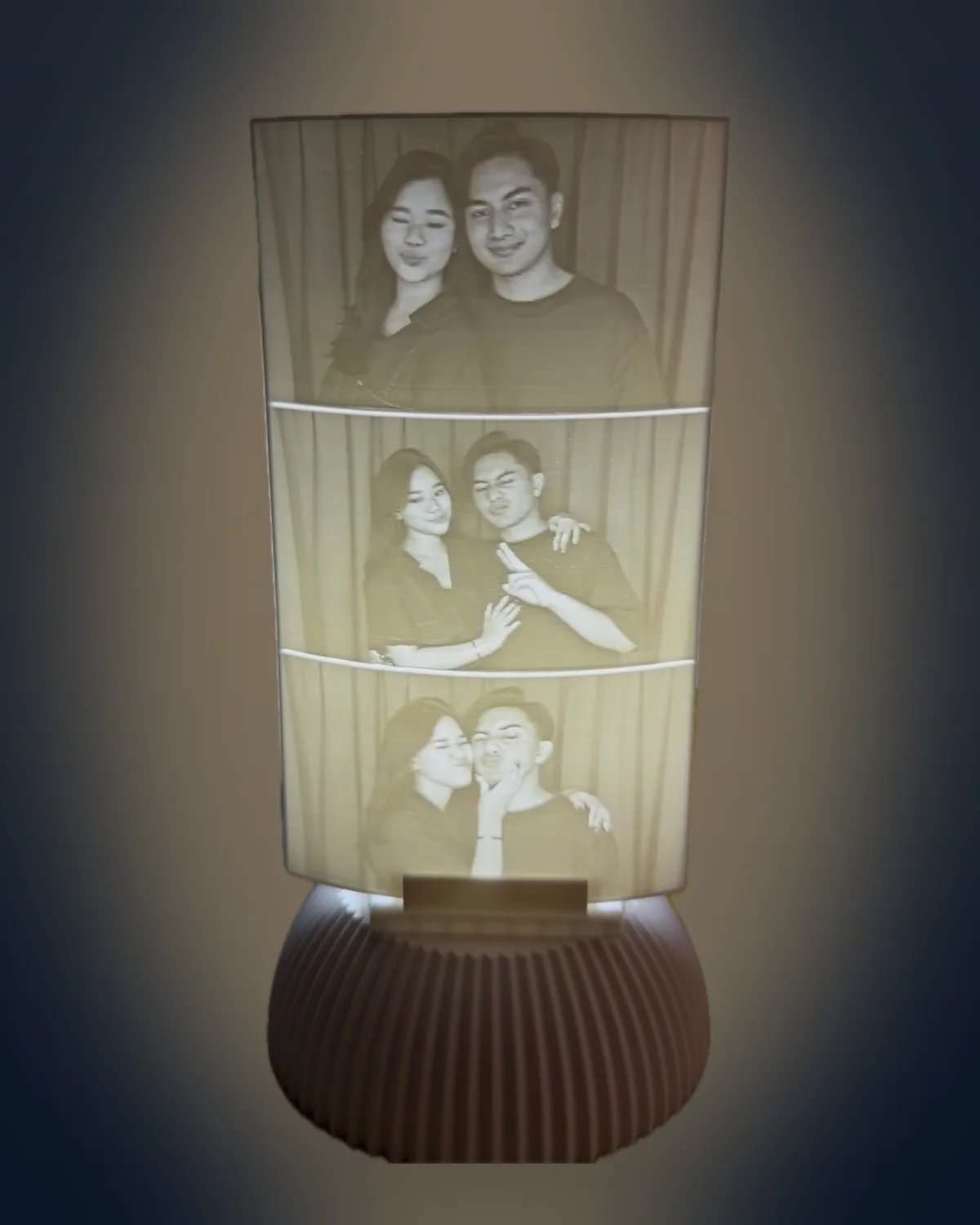 Photo-booth strip lithophane glowing warm white on its stand